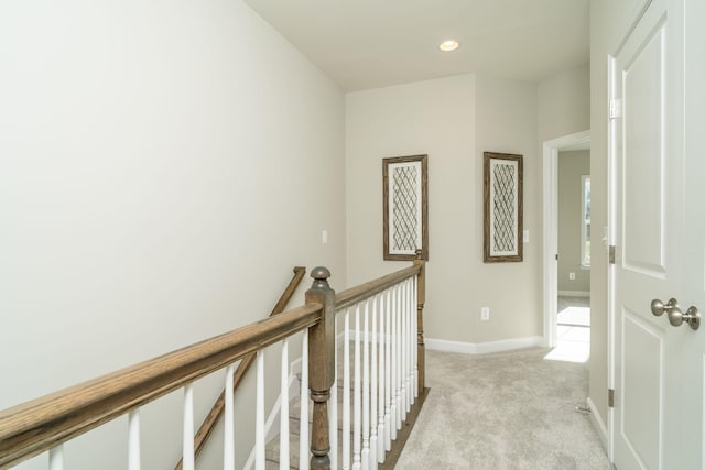 corridor with recessed lighting, light colored carpet, baseboards, and an upstairs landing