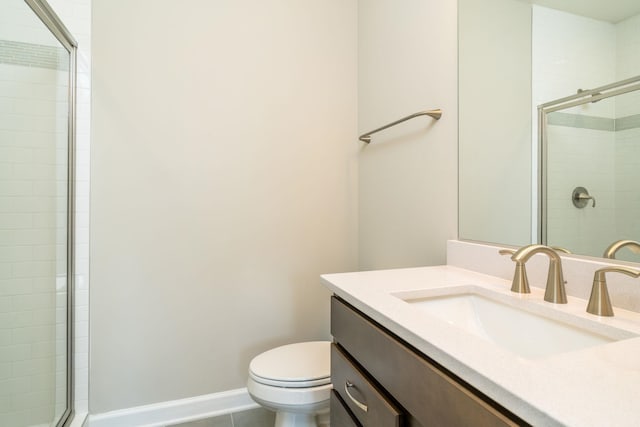 bathroom with baseboards, toilet, tiled shower, tile patterned floors, and vanity