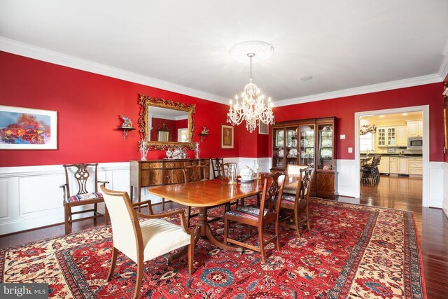 dining area with an inviting chandelier, crown molding, and dark hardwood / wood-style flooring