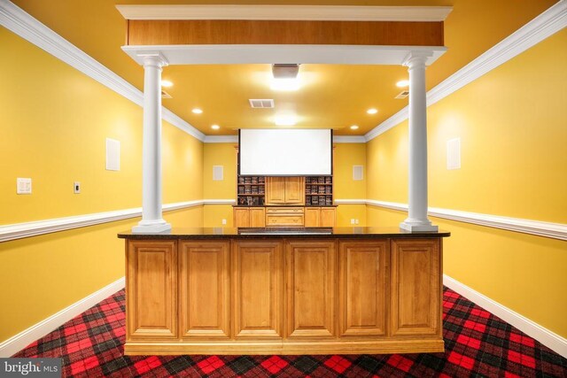 bar featuring ornamental molding and ornate columns