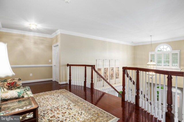 sitting room featuring dark wood-type flooring, ornamental molding, and a notable chandelier