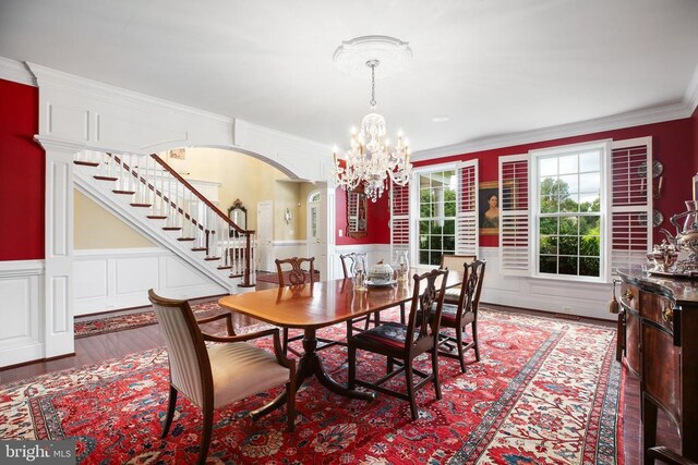 dining room with crown molding, hardwood / wood-style floors, and an inviting chandelier