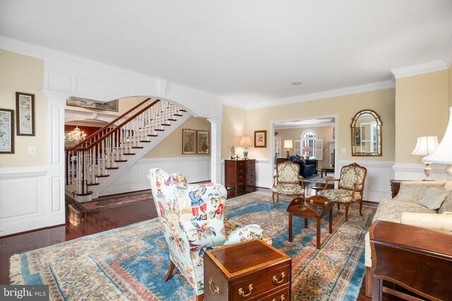 living room with dark hardwood / wood-style flooring, ornamental molding, and decorative columns