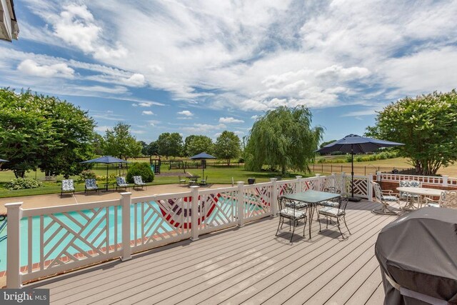 wooden deck featuring a grill and a lawn