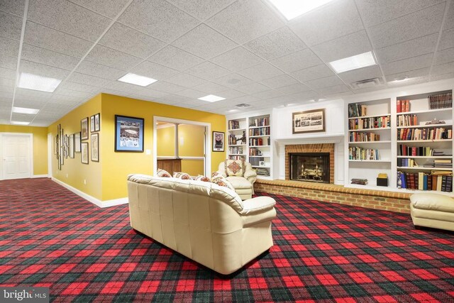 carpeted living room with built in features and a brick fireplace