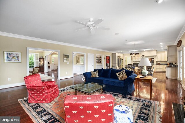 living room with crown molding, ceiling fan with notable chandelier, and dark hardwood / wood-style floors