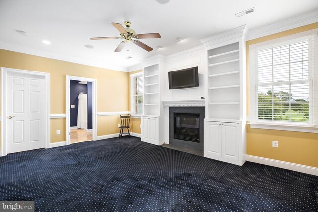 unfurnished living room featuring dark colored carpet, ceiling fan, and crown molding