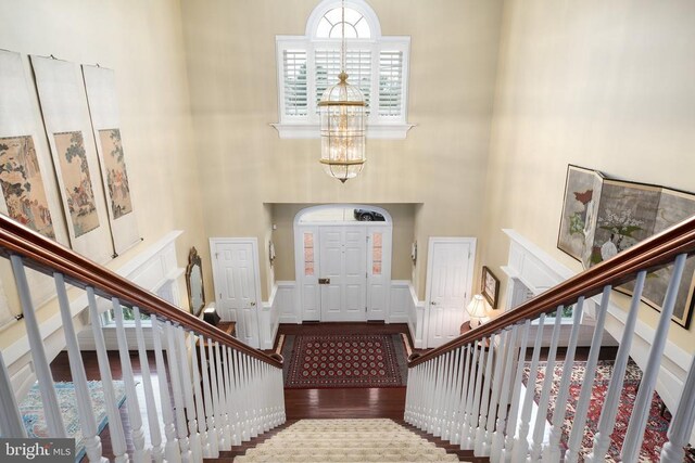 entrance foyer featuring an inviting chandelier, hardwood / wood-style floors, and a high ceiling