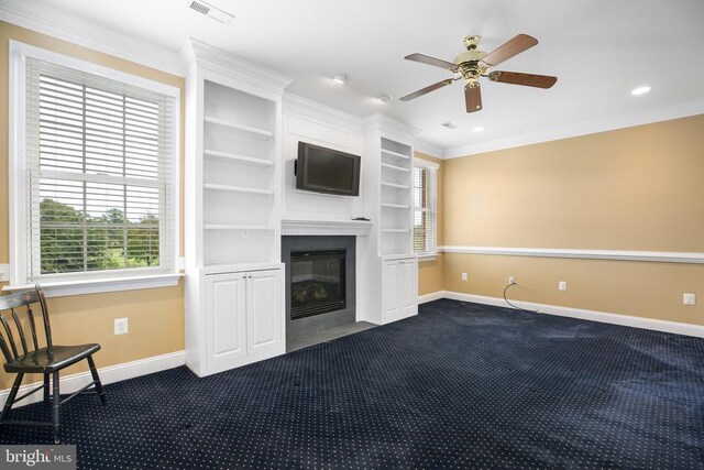 unfurnished living room with ornamental molding, ceiling fan, and carpet