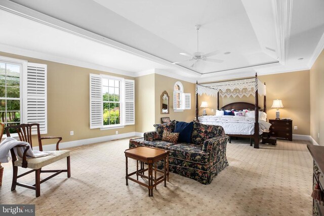 bedroom featuring ceiling fan, light colored carpet, ornamental molding, and a raised ceiling