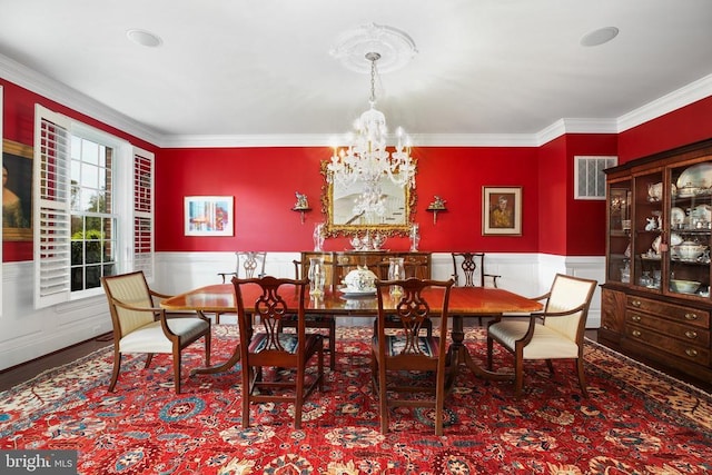 dining room with crown molding, wood-type flooring, and a chandelier