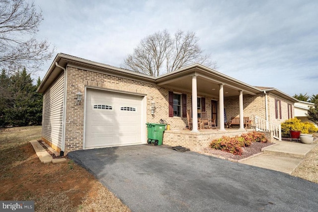 ranch-style home with aphalt driveway, covered porch, brick siding, and a garage