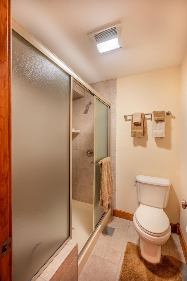 bathroom with tile patterned flooring, toilet, and walk in shower