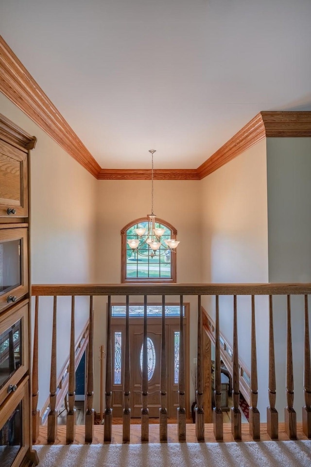 foyer featuring a towering ceiling, ornamental molding, and a chandelier