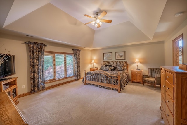 carpeted bedroom featuring ceiling fan and a raised ceiling