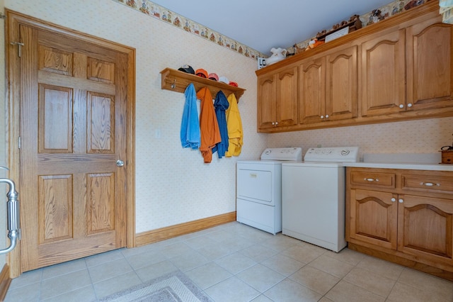 laundry room featuring cabinets, light tile patterned floors, and washing machine and clothes dryer