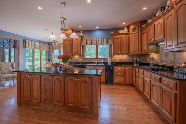 kitchen featuring pendant lighting, backsplash, light hardwood / wood-style flooring, and a kitchen island