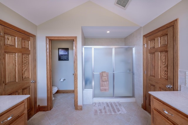 bathroom featuring lofted ceiling, vanity, toilet, and a shower with shower door