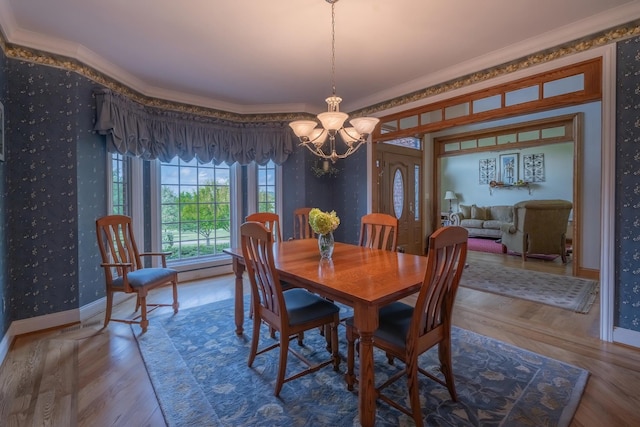 dining space with an inviting chandelier, ornamental molding, and wood-type flooring