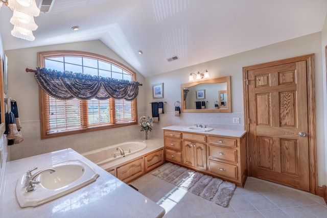 bathroom featuring a tub to relax in, vaulted ceiling, tile walls, vanity, and tile patterned flooring