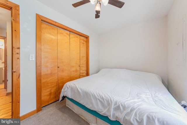 bedroom with light colored carpet, a closet, and ceiling fan