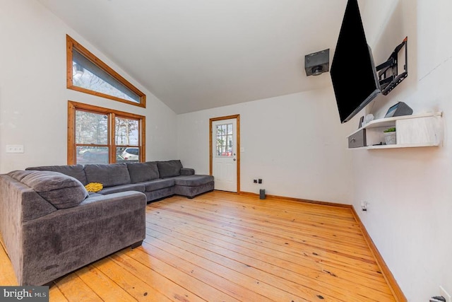 living room featuring wood-type flooring, vaulted ceiling, and a healthy amount of sunlight