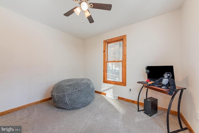 living area featuring ceiling fan and carpet