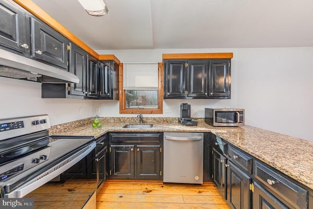 kitchen featuring light stone counters, appliances with stainless steel finishes, sink, and light wood-type flooring