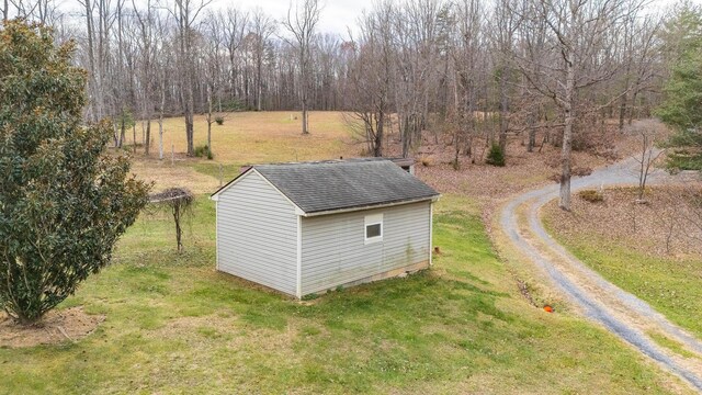 view of outbuilding featuring a rural view and a lawn