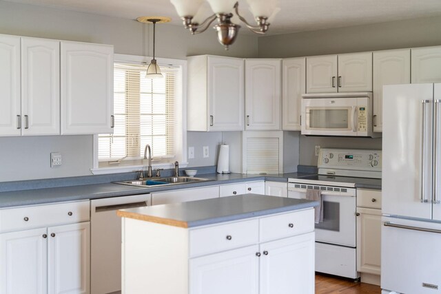 kitchen featuring pendant lighting, white appliances, sink, and white cabinets