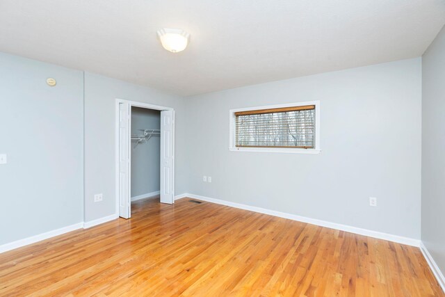 unfurnished bedroom with a closet and light wood-type flooring