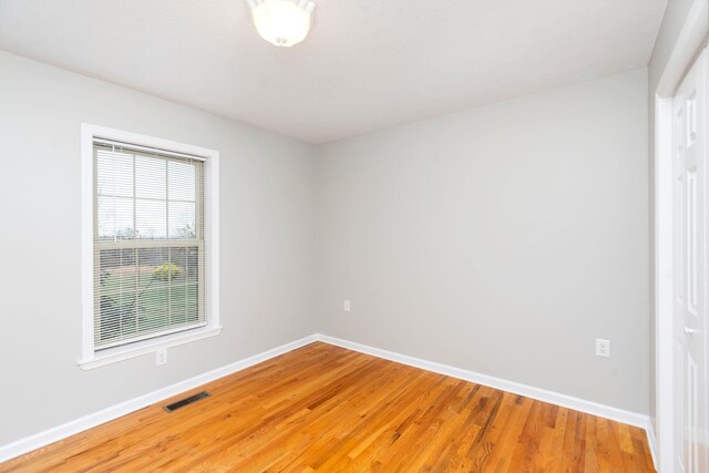 unfurnished room with hardwood / wood-style flooring