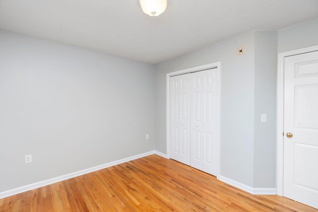 unfurnished bedroom with a closet and light hardwood / wood-style flooring