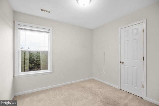 carpeted spare room with baseboards and visible vents