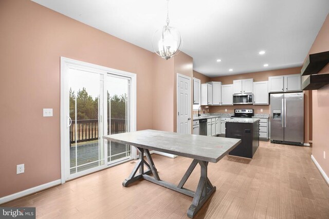 dining area with light wood finished floors, recessed lighting, baseboards, and an inviting chandelier