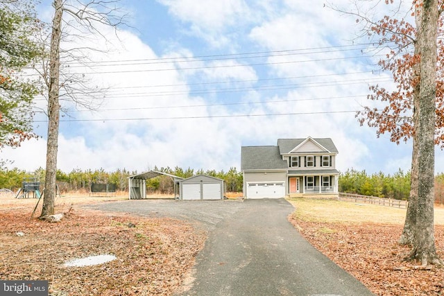 view of front of home featuring covered porch, driveway, and an outdoor structure