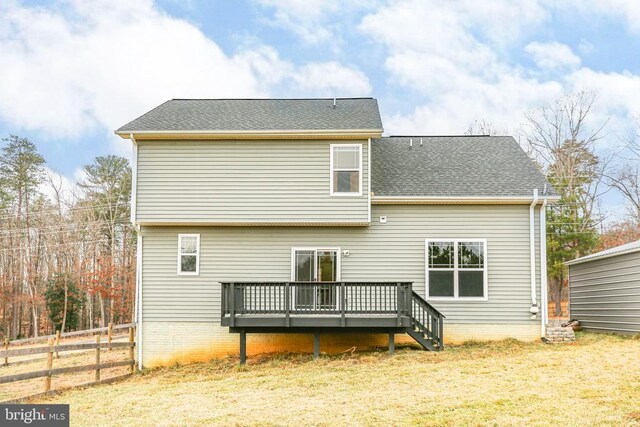 back of property featuring a yard, roof with shingles, fence, and a deck