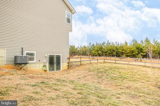 view of yard featuring fence and central air condition unit