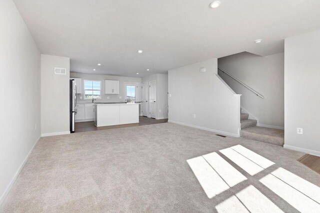 unfurnished living room featuring light carpet