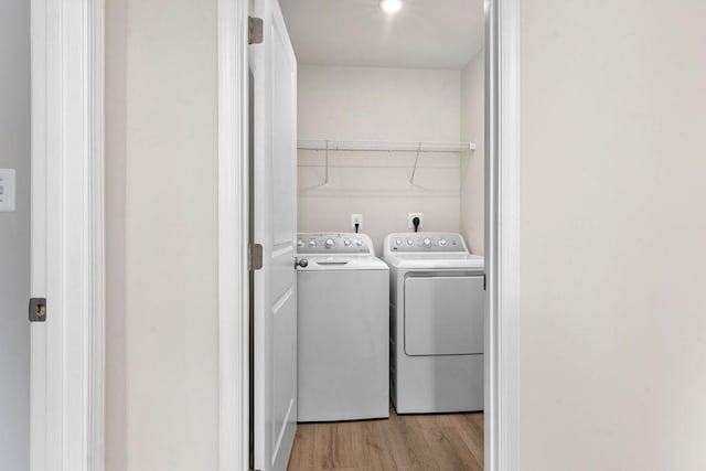 laundry area featuring light hardwood / wood-style flooring and washing machine and dryer