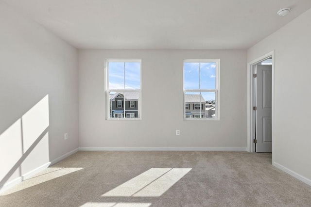 unfurnished room featuring light carpet