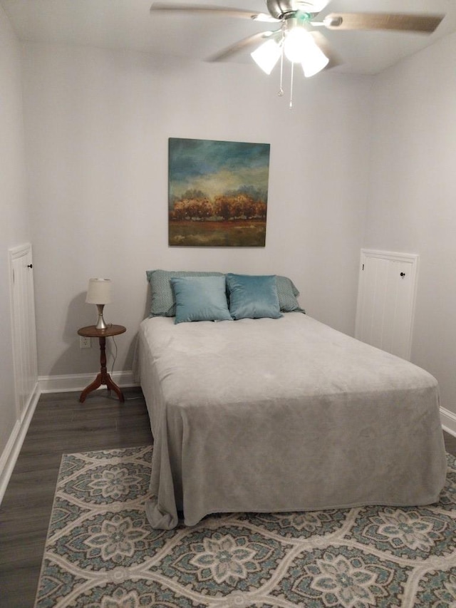 bedroom with dark hardwood / wood-style flooring and ceiling fan