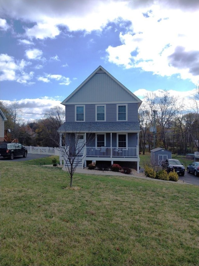 view of front of property featuring a shed, a front lawn, and a porch