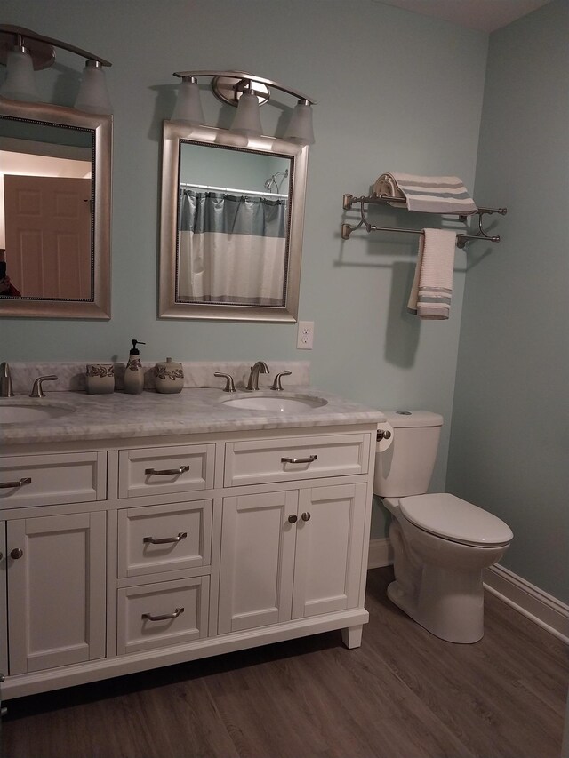 bathroom featuring hardwood / wood-style flooring, vanity, toilet, and a shower with curtain