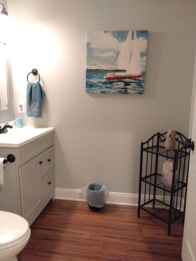 bathroom featuring vanity, toilet, and hardwood / wood-style floors