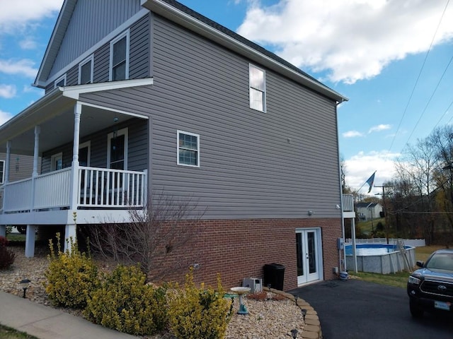 view of property exterior featuring french doors and a fenced in pool