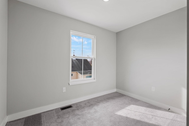 carpeted spare room featuring baseboards and visible vents