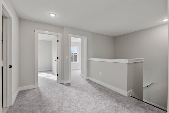 carpeted spare room featuring baseboards and recessed lighting