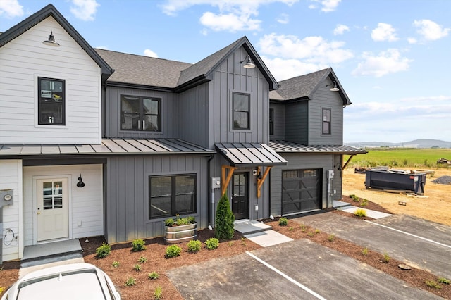 modern inspired farmhouse with board and batten siding, a standing seam roof, a shingled roof, and a mountain view