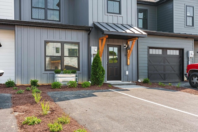 view of exterior entry with a garage and board and batten siding